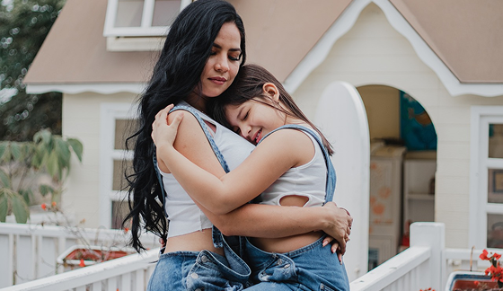A mother hugging her teenage girl